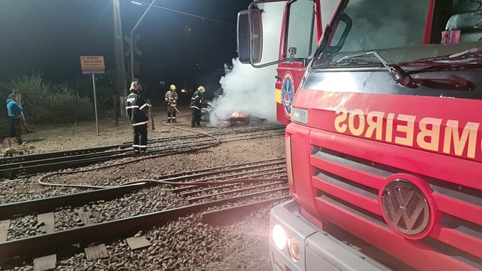 Bombeiros combatem incêndio em veículo próximo a linha férrea